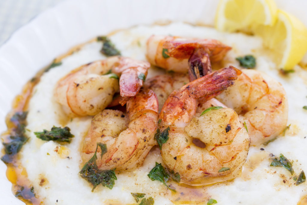 A hearty bowl of shrimp over buttery, savory grits.