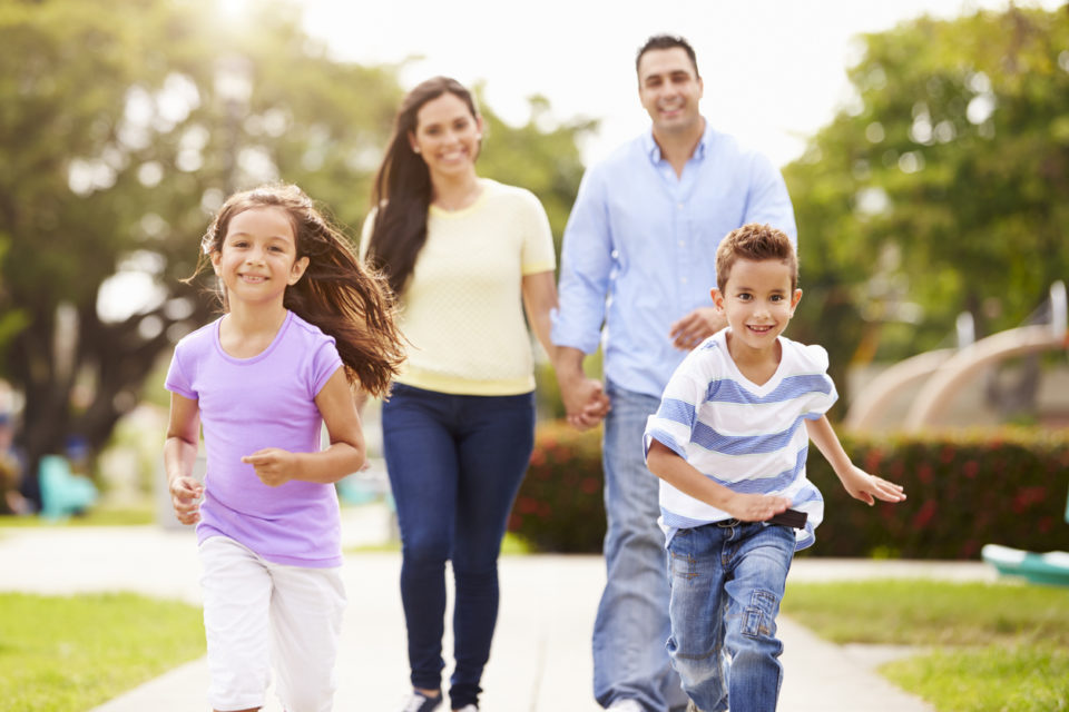 Family Walking In Park Together.