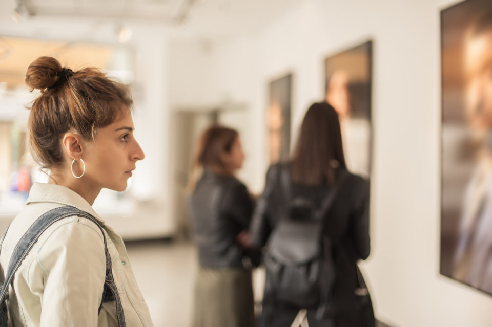Group of woman looking at modern painting in art gallery.