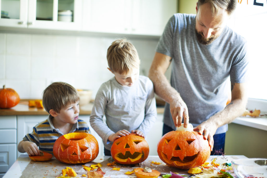 family carving pumpkins in kitchen