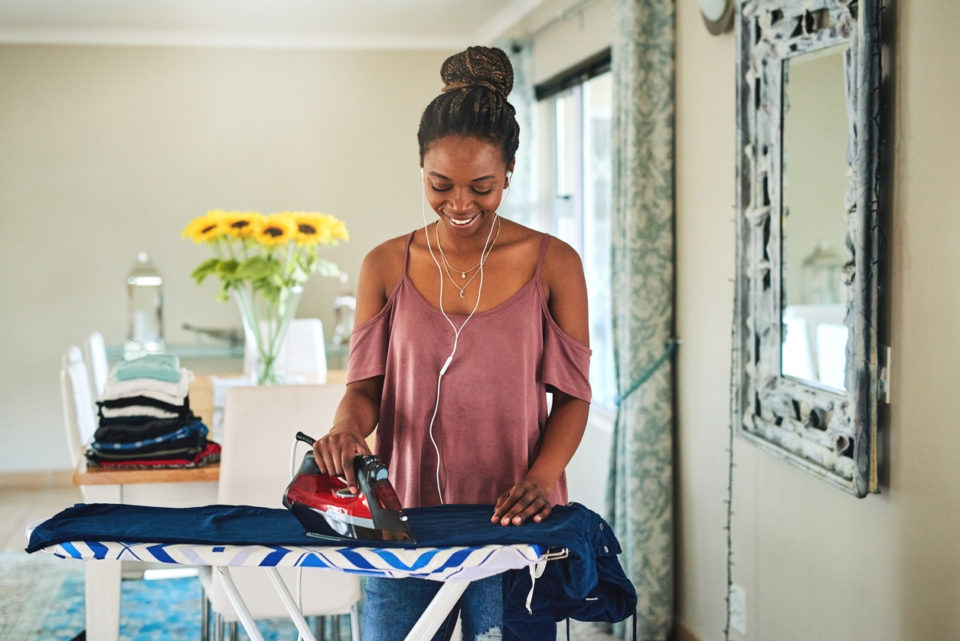 Cropped shot of a young woman ironing her washed clothes at home