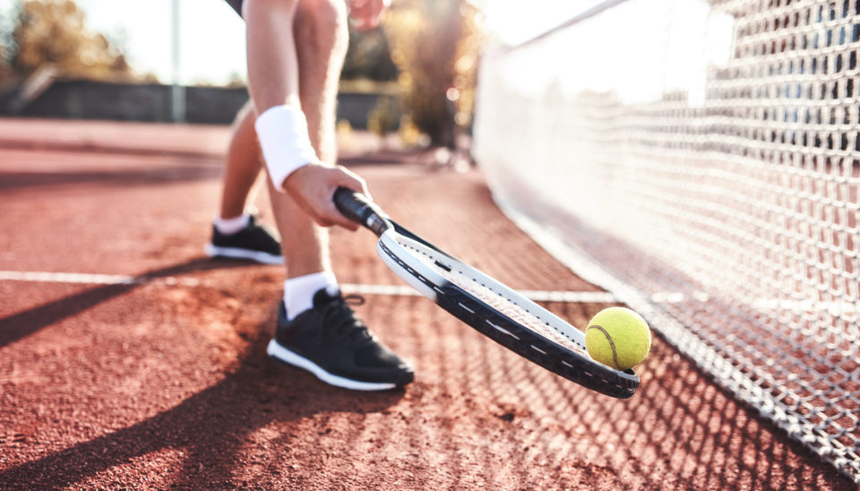 Young man playing tennis, close up photo.