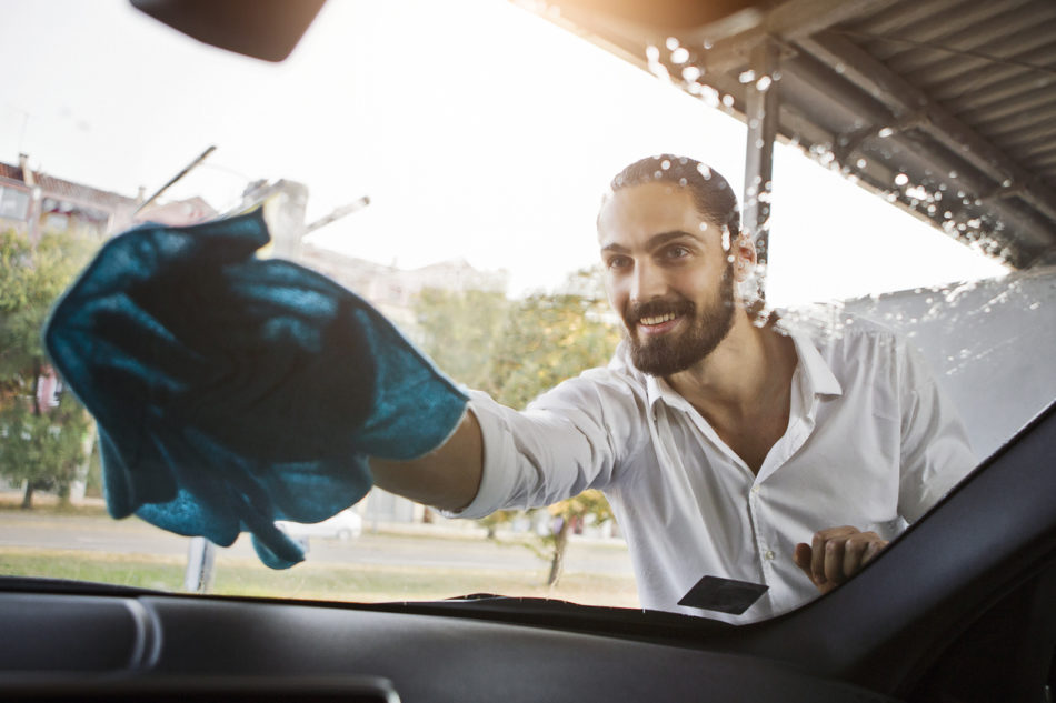 Young man washing windshield