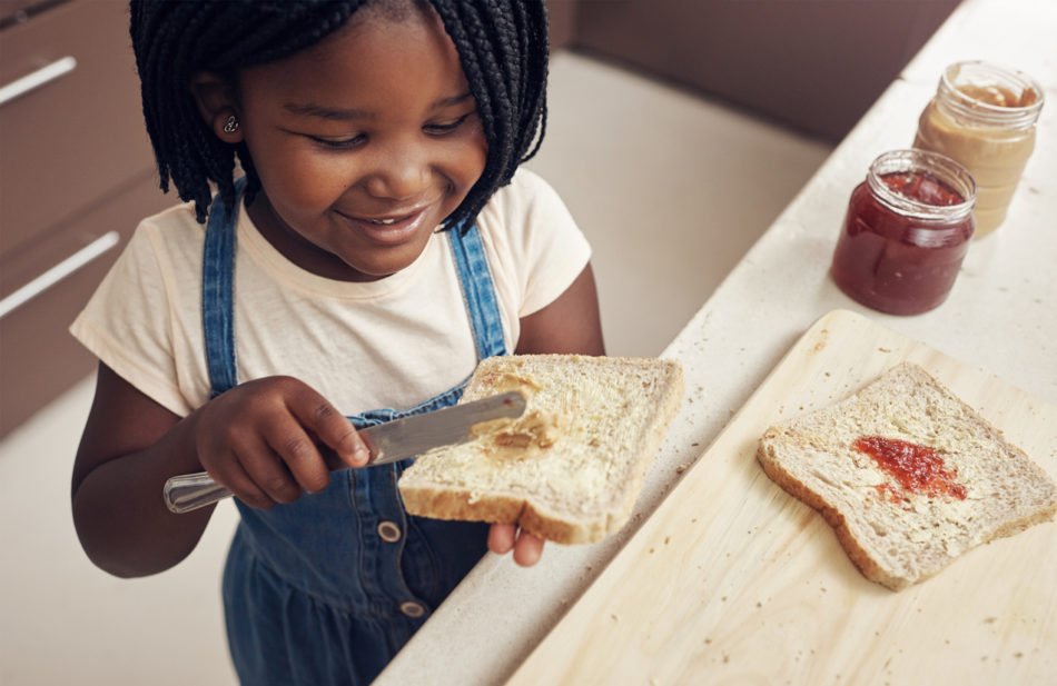 Cropped shot of an adorable little girl making lunch for herself in the kitchen at home