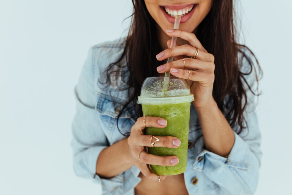 Smiling woman drinking fresh juice