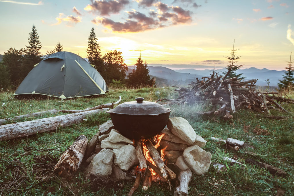 Tourist camp with fire, tent, and firewood