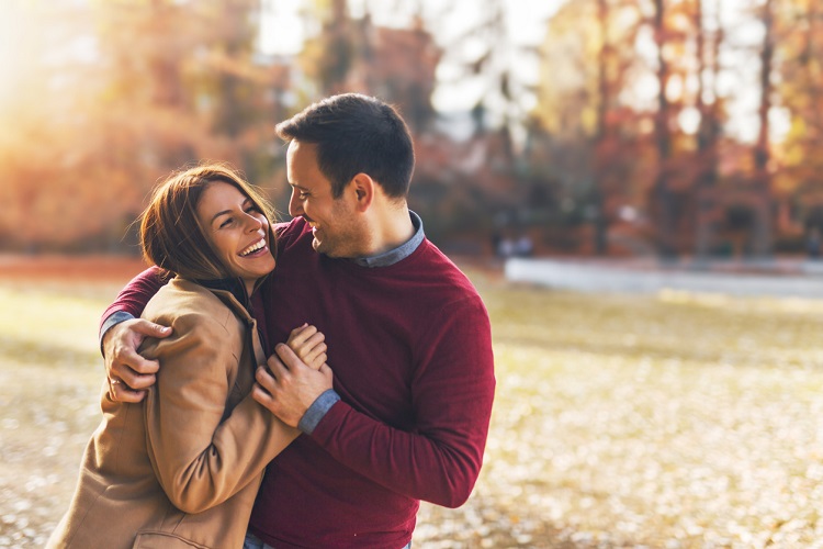 Couple in love hugging and enjoying at public park in autumn