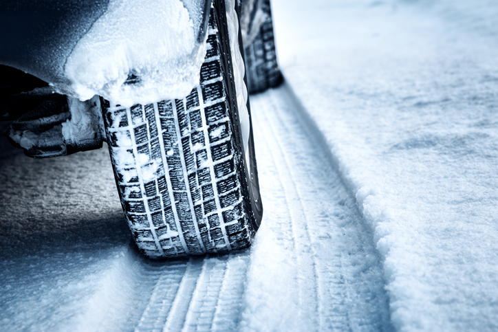 Closeup of car tires in winter on the road covered with snow