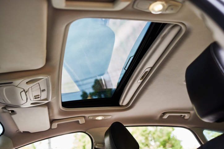 Panoramic Glass and sliding system sunroof on car. Blue Skies in car Through Sunroof.