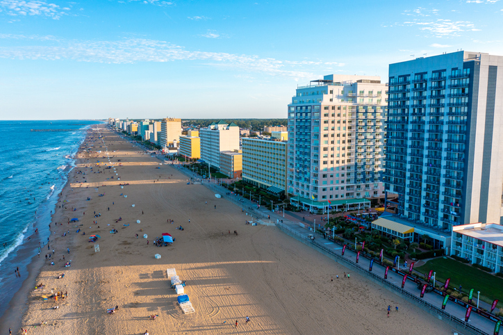 Aerial view of the Virginia Beach oceanfront looking south at sunset. vacationers on the beach and the boardwalk. ocean waves breaking