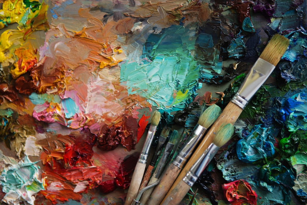 artists brushes and oil paints on wooden palette.